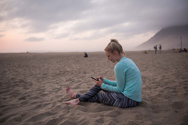 Photo of a participant of HMDS Fuerteventura at the bivouac with her phone