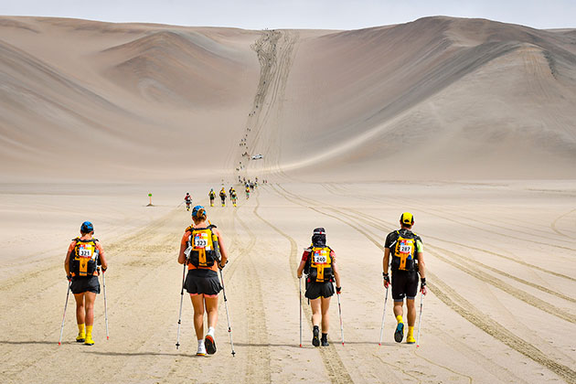 4 people walking in the desert
