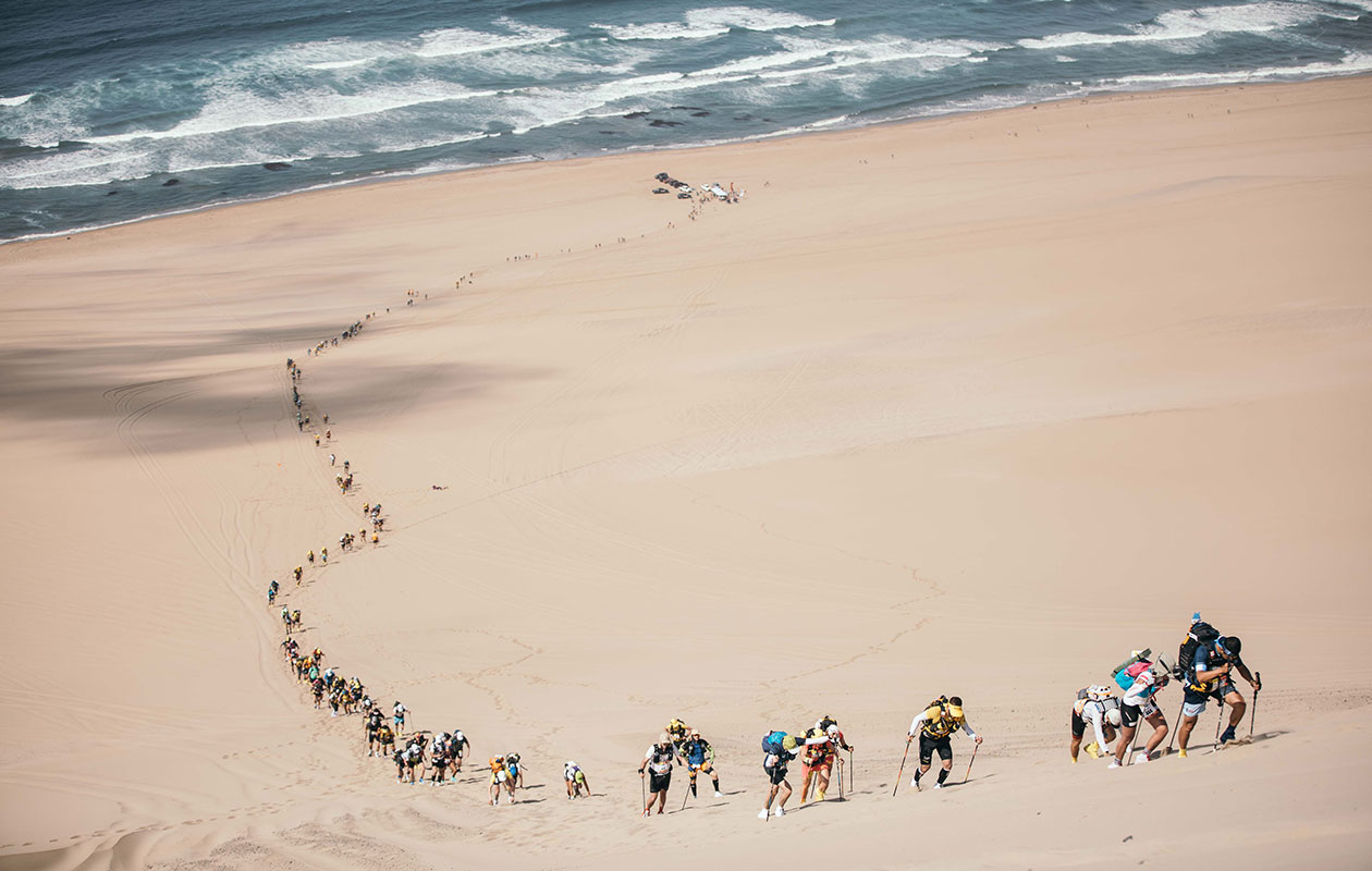 Participants climbing on a dune sand